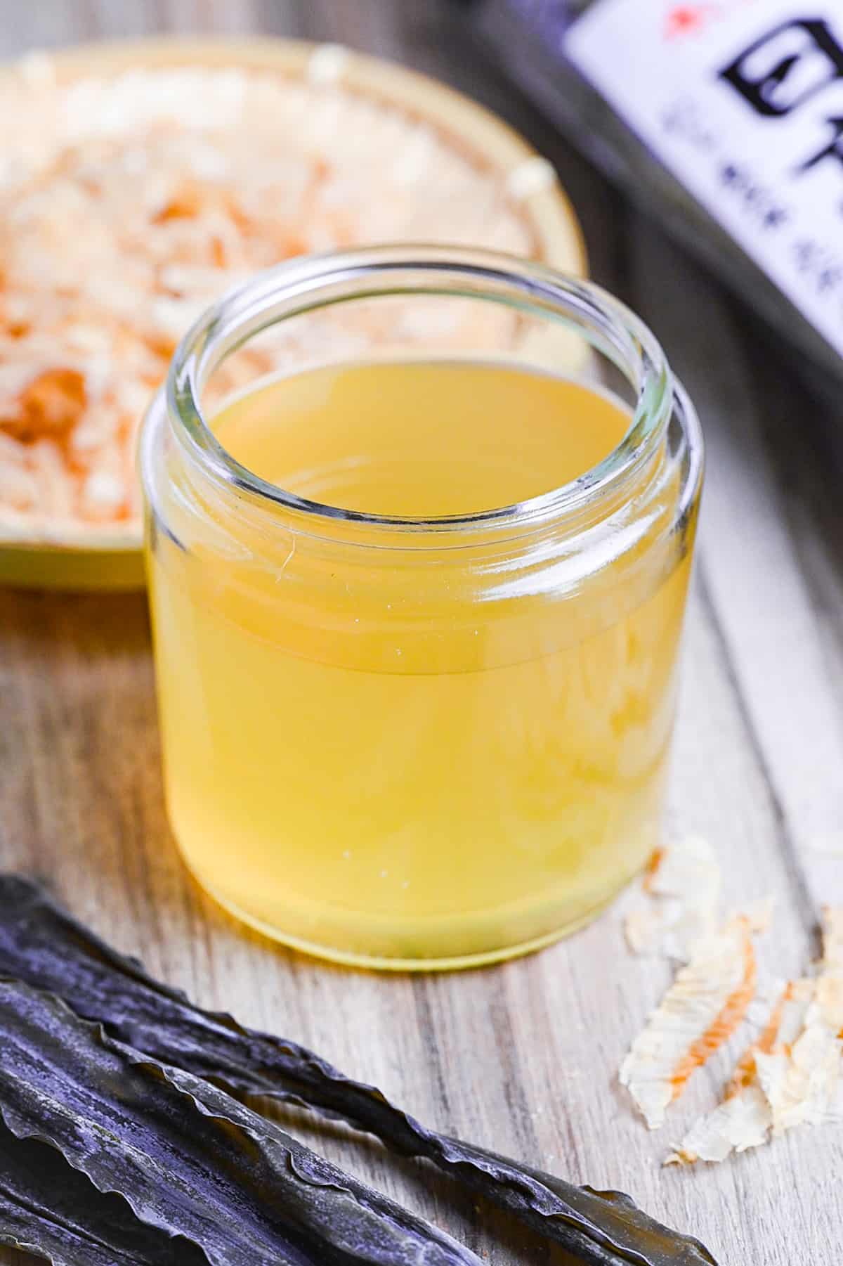 awase dashi in a jar with kombu in the foreground and katsuobushi in the background