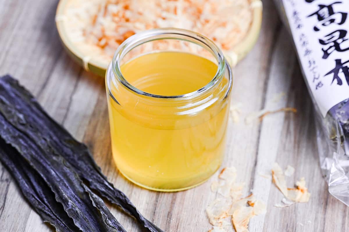 awase dashi in a jar with kombu in the foreground and katsuobushi in the background