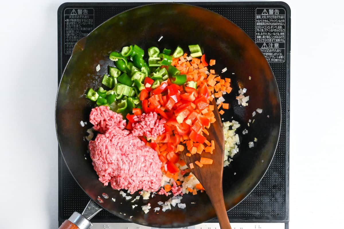 Frying ground beef/pork and vegetables with aromatics in a frying pan