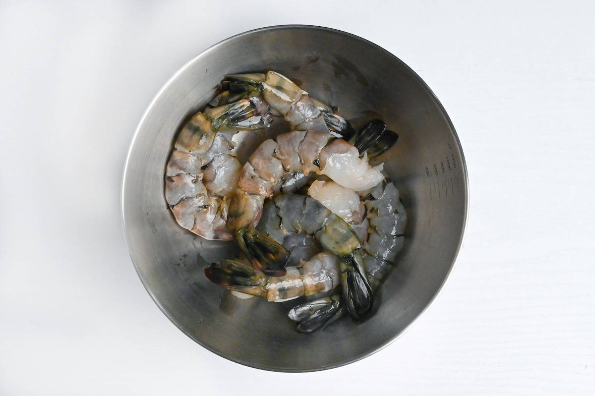 raw black tiger shrimp in a steel mixing bowl