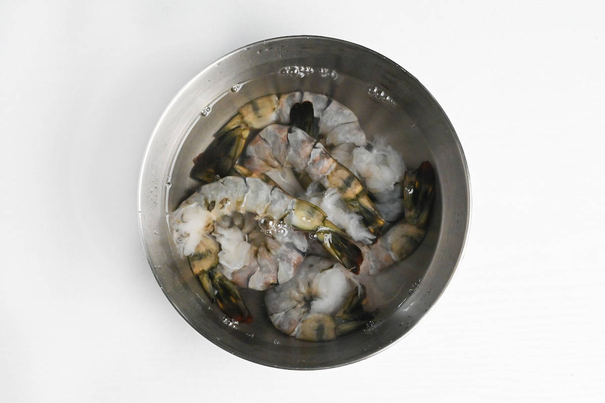 raw black tiger shrimp in a bowl of water