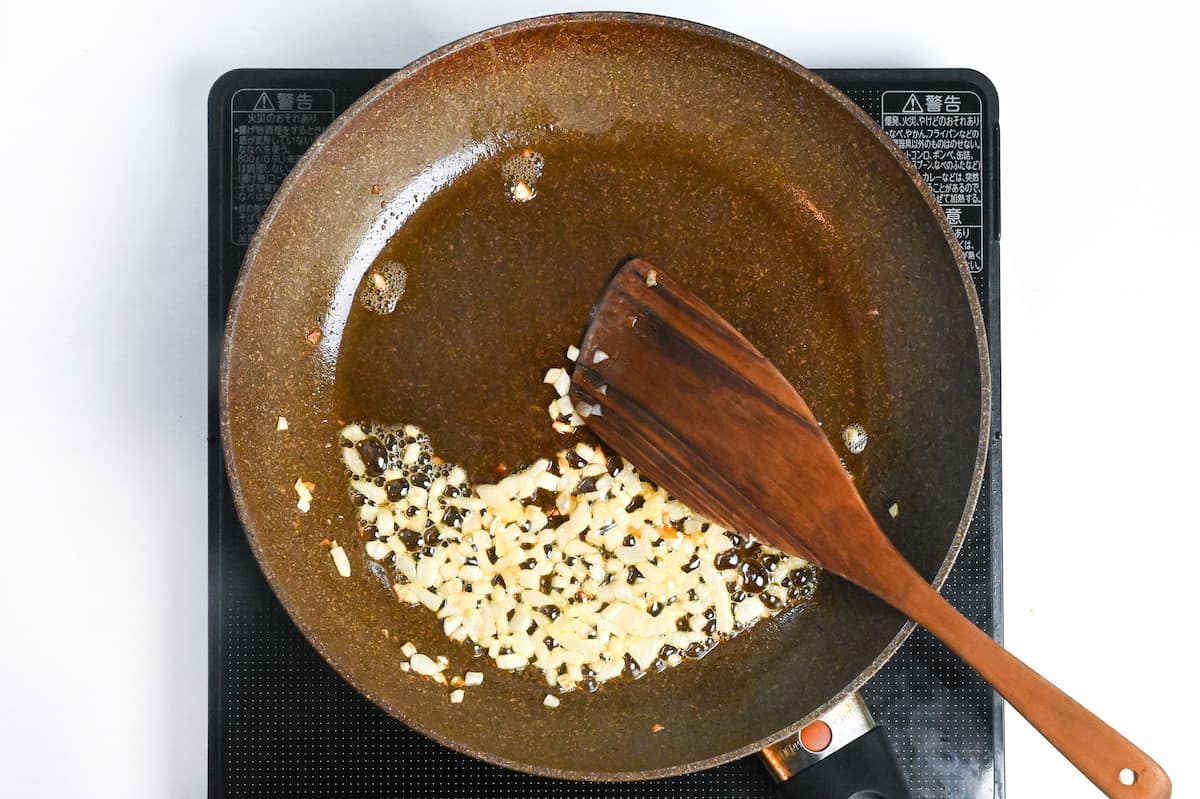 softened onions frying in butter in a pan