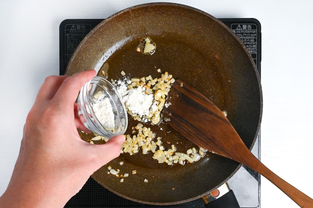 sprinkling flour over softened diced onions