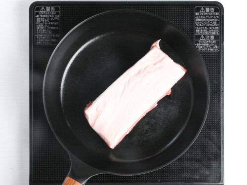 sealing a block of pork belly in a frying pan