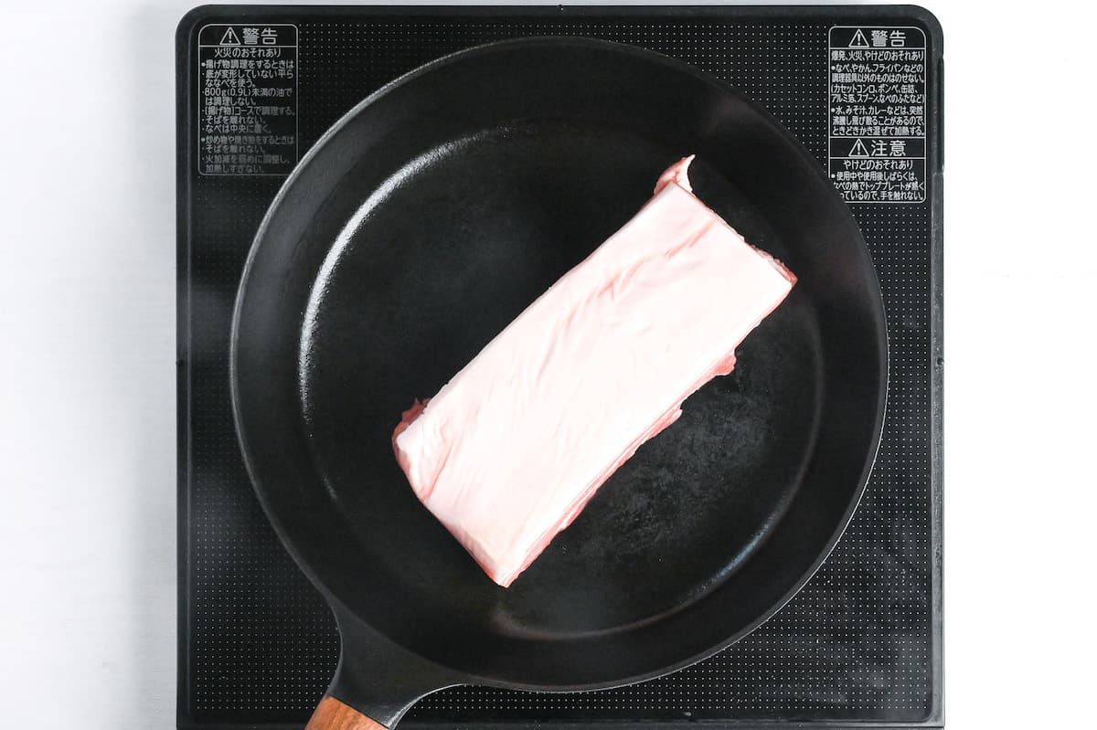 sealing a block of pork belly in a frying pan