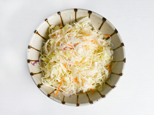 rice and shredded cabbage stacked in a striped bowl