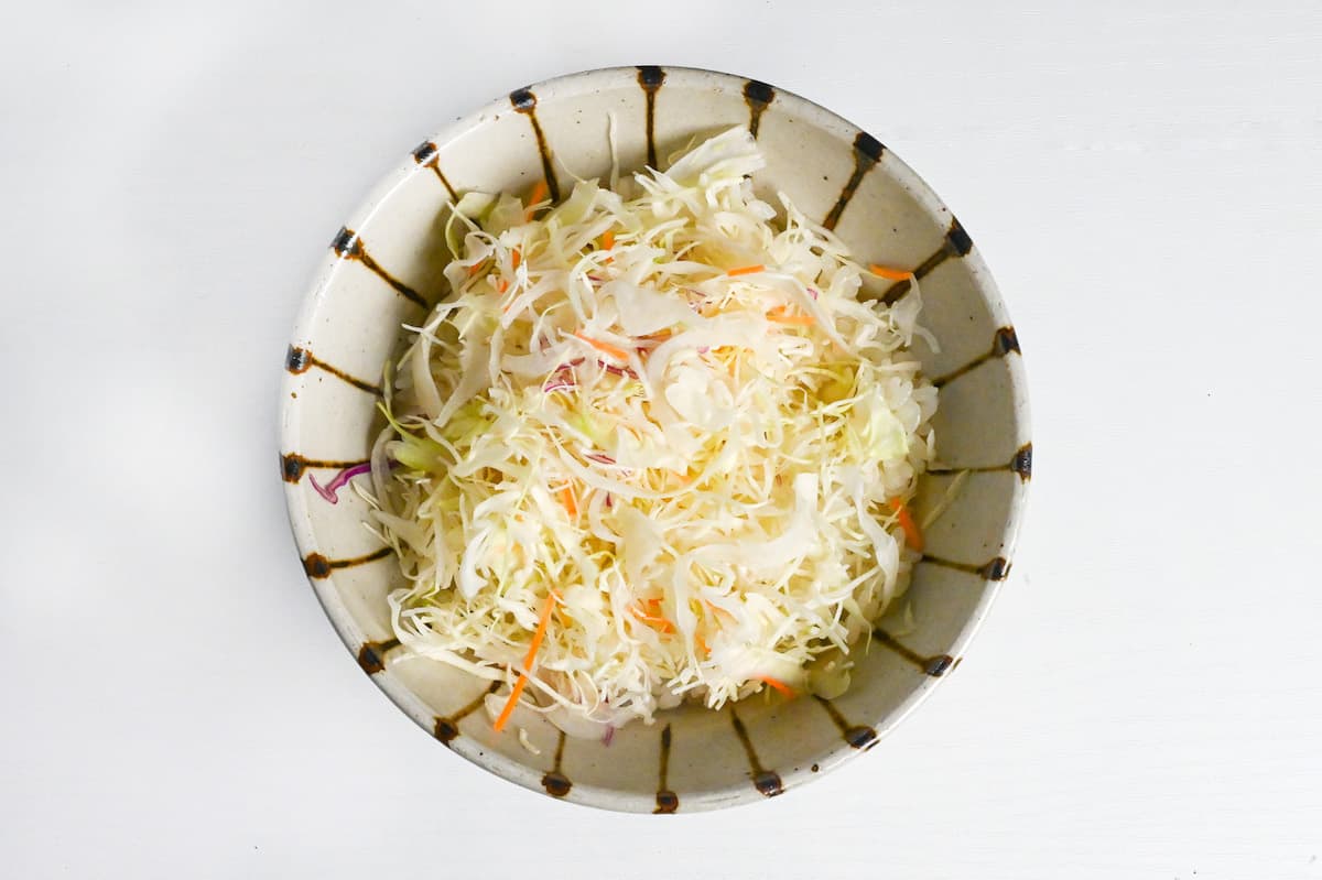 rice and shredded cabbage stacked in a striped bowl