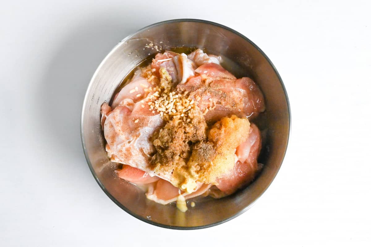 chicken thigh and marinade ingredients in a bowl