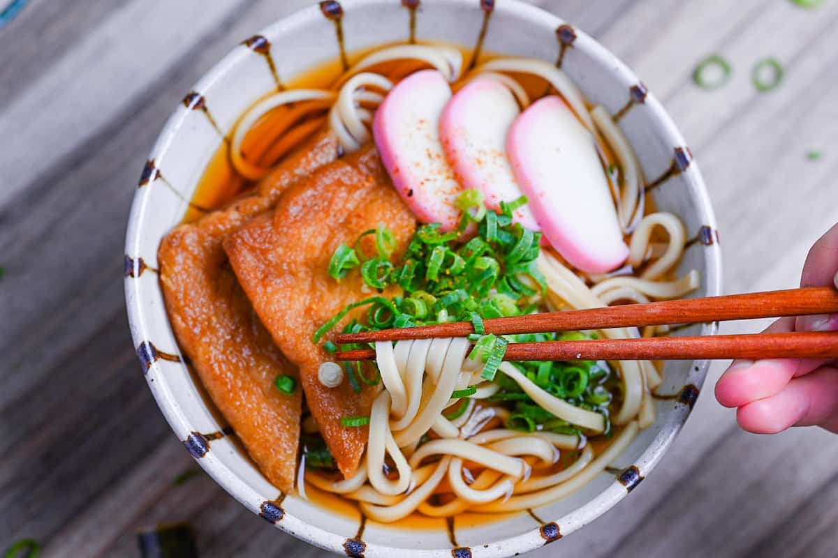 holding udon noodles with wooden chopsticks