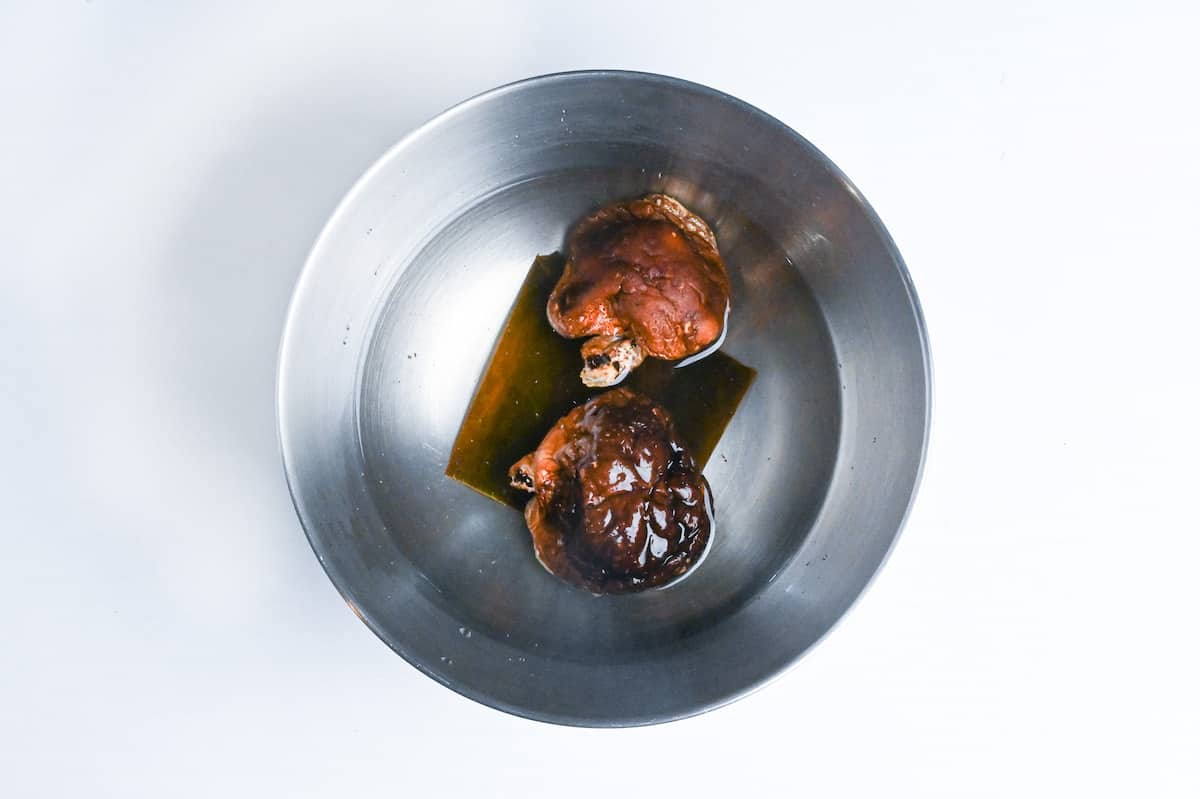 soaking dried shiitake mushrooms and kombu in a bowl of water