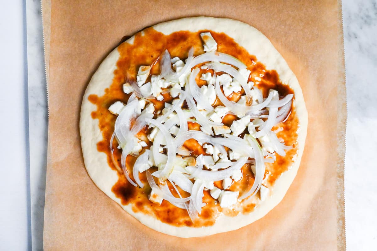 teriyaki pizza topped with mozzarella and sliced onions