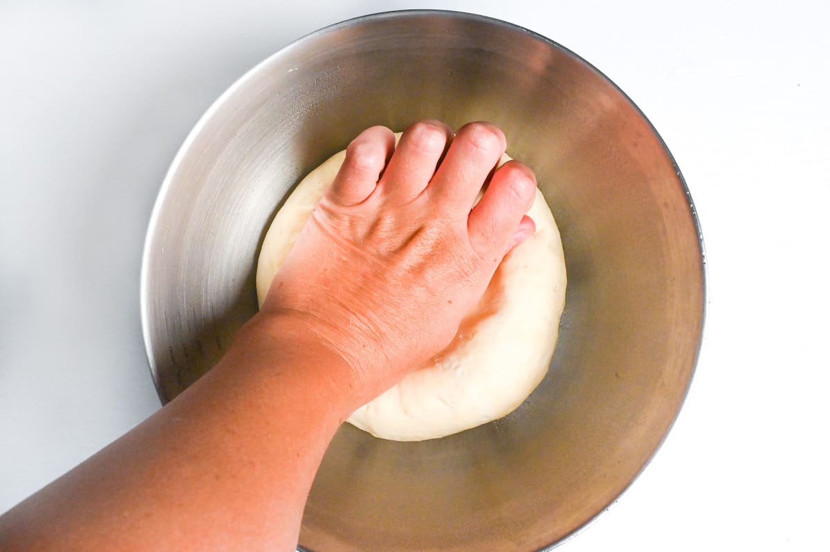 pressing air out of pizza dough base