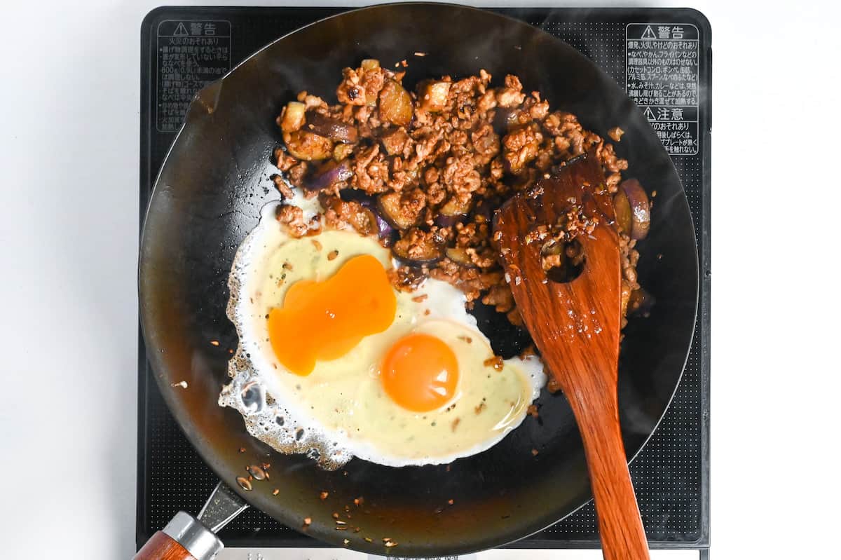 frying eggs in the same pan with the other ingredients pushed to the side