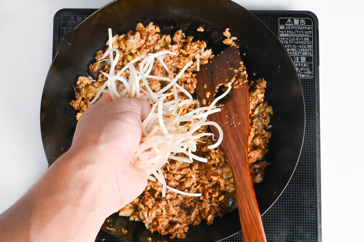 adding beansprouts to wok