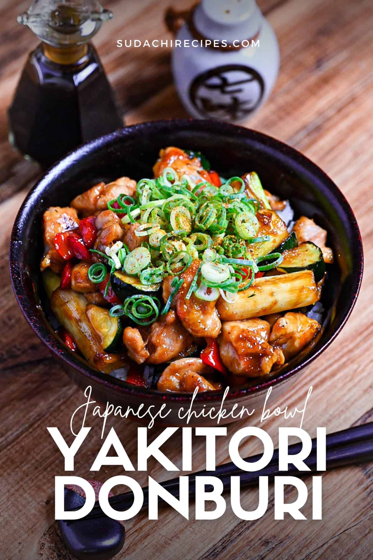 Yakitori donburi made with chicken, zucchini, green onions and bell peppers cooked in a yakitori-style tare (sauce) served in a black bowl and topped with green onion and shichimi
