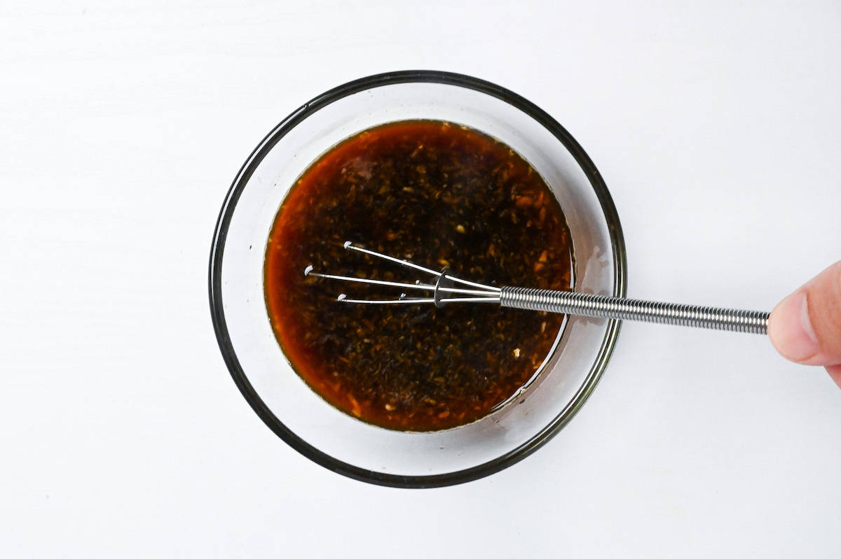 whisking yakitori sauce in a small glass bowl