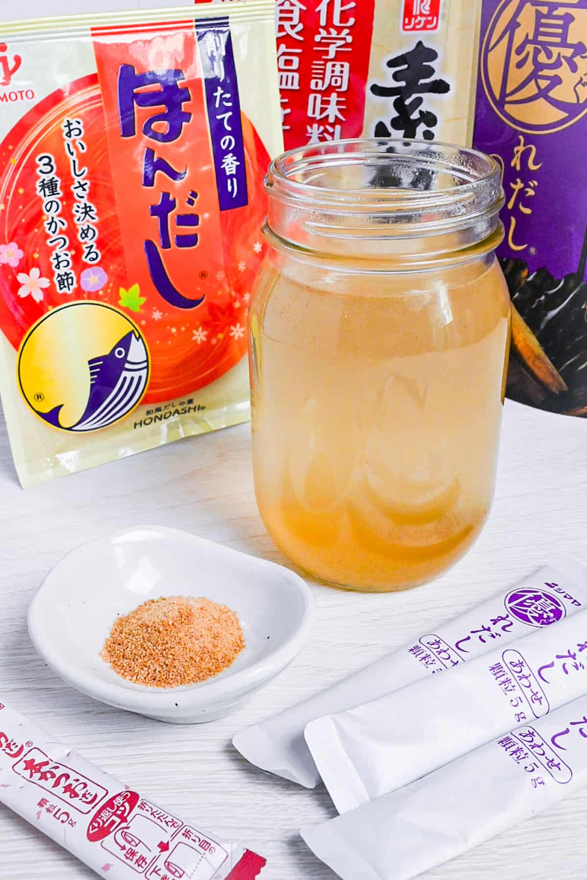 dashi made with granules in a jar surrounded by various packs of dashi granules