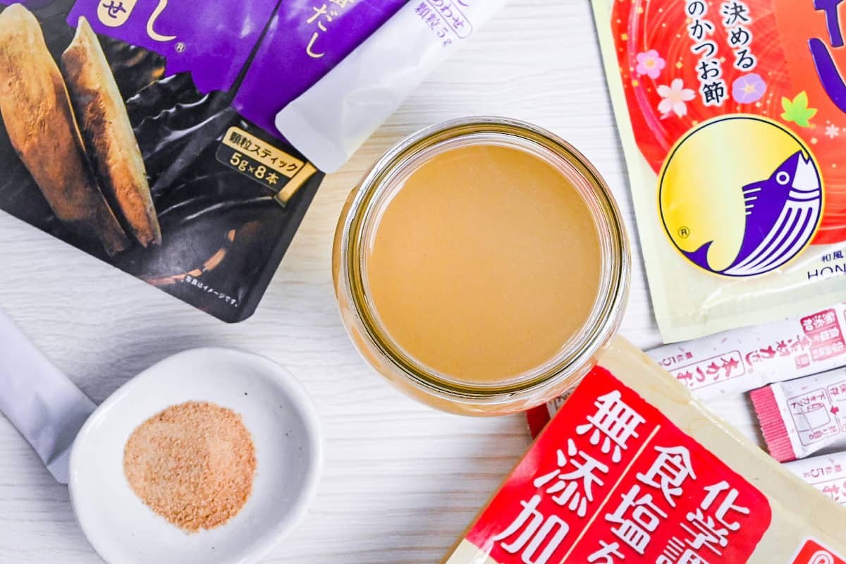 dashi made with granules in a jar surrounded by various packs of dashi granules