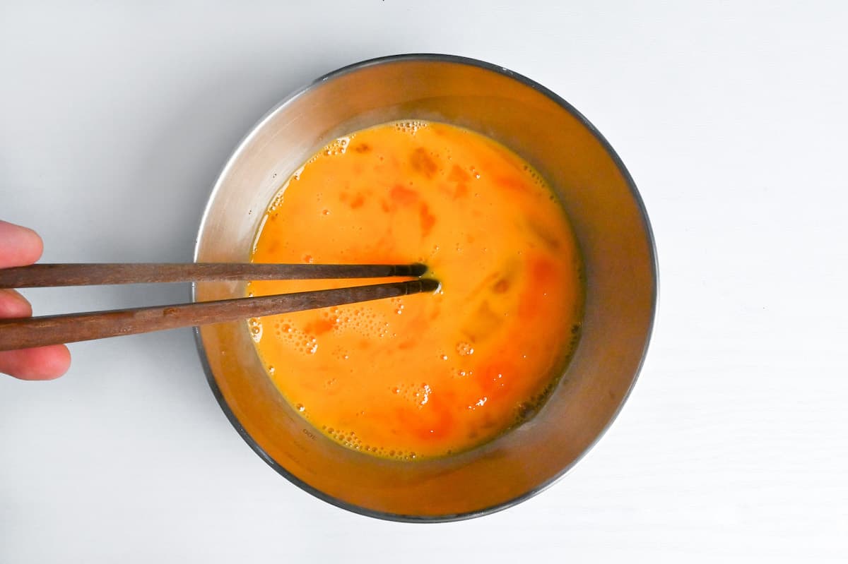 whisking egg in a mixing bowl