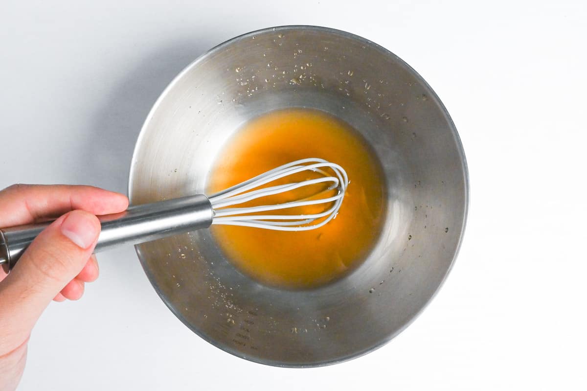 whisking dashi and condiments in a mixing bowl