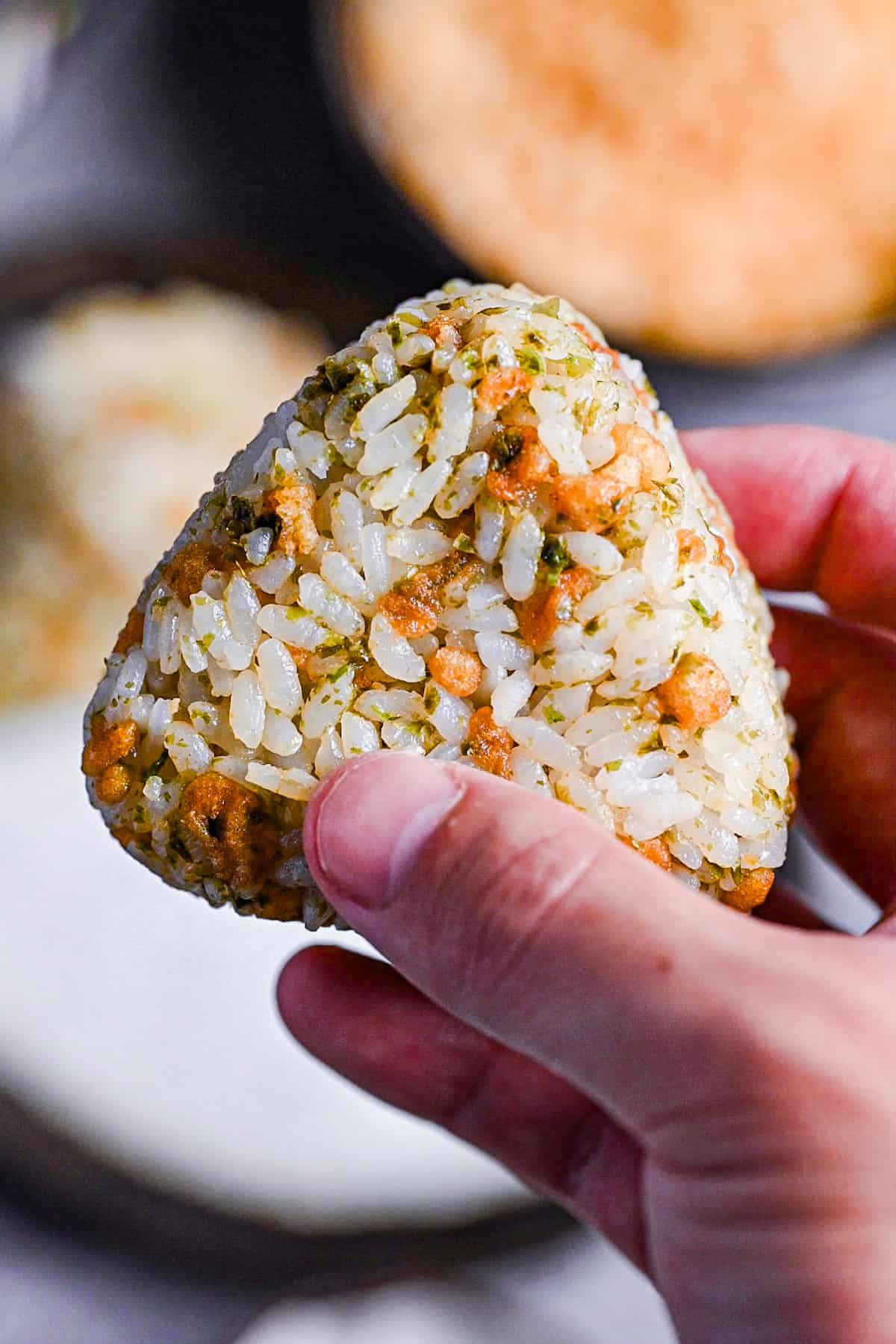 a hand holding devil's onigiri close up