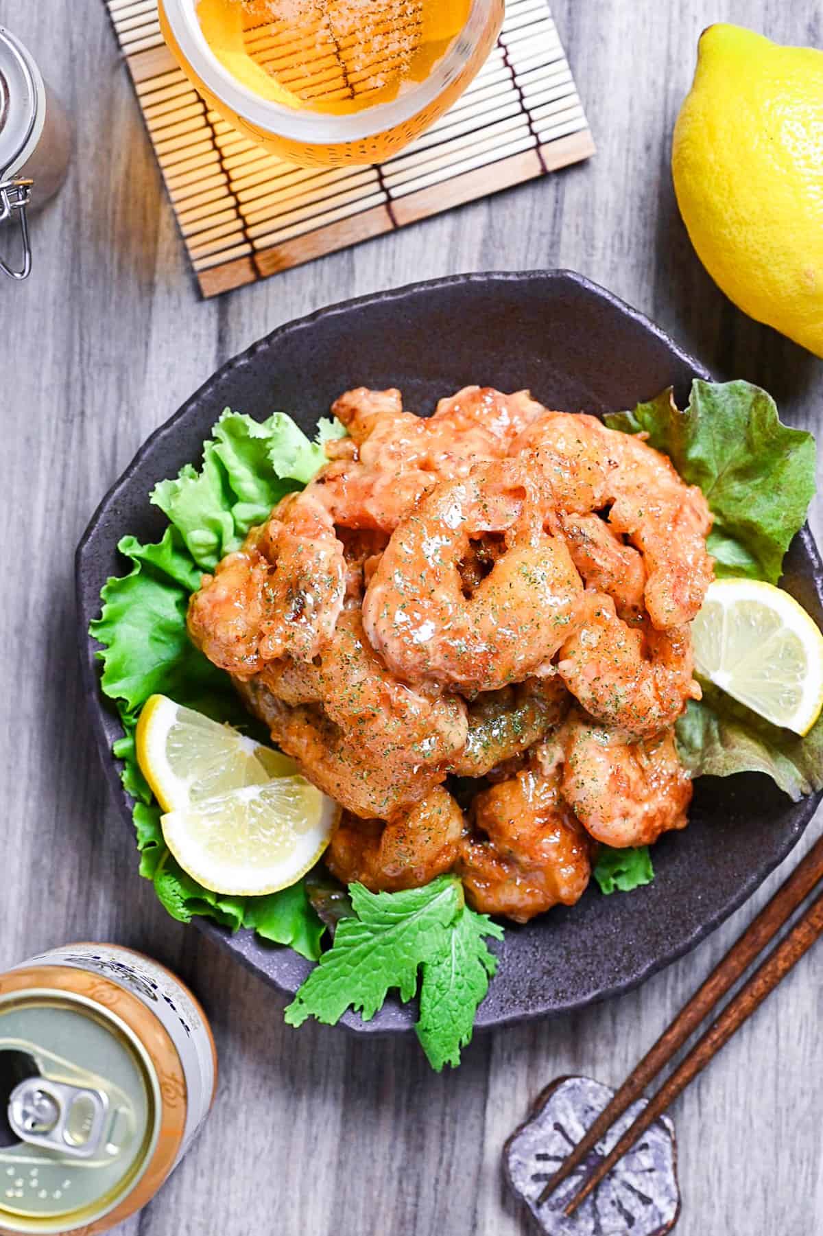 Ebi Mayo (Fried Shrimp in Mayonnaise Sauce) on a brown plate with salad and lemon wedges