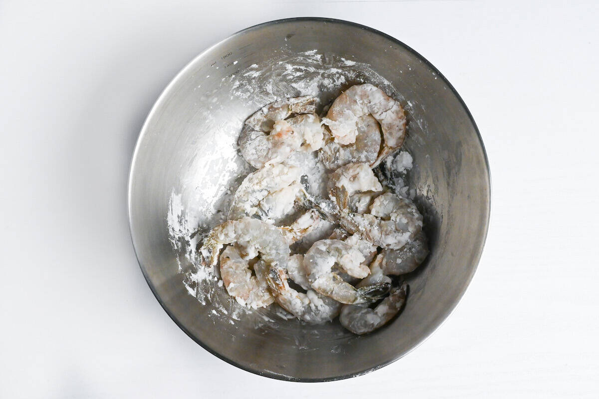 shrimps coated with starch in a steel mixing bowl