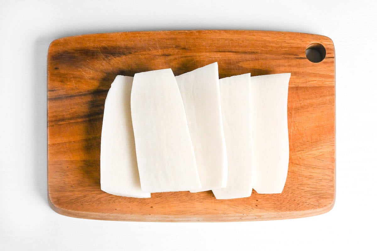 5 slices of daikon radish on a wooden chopping board