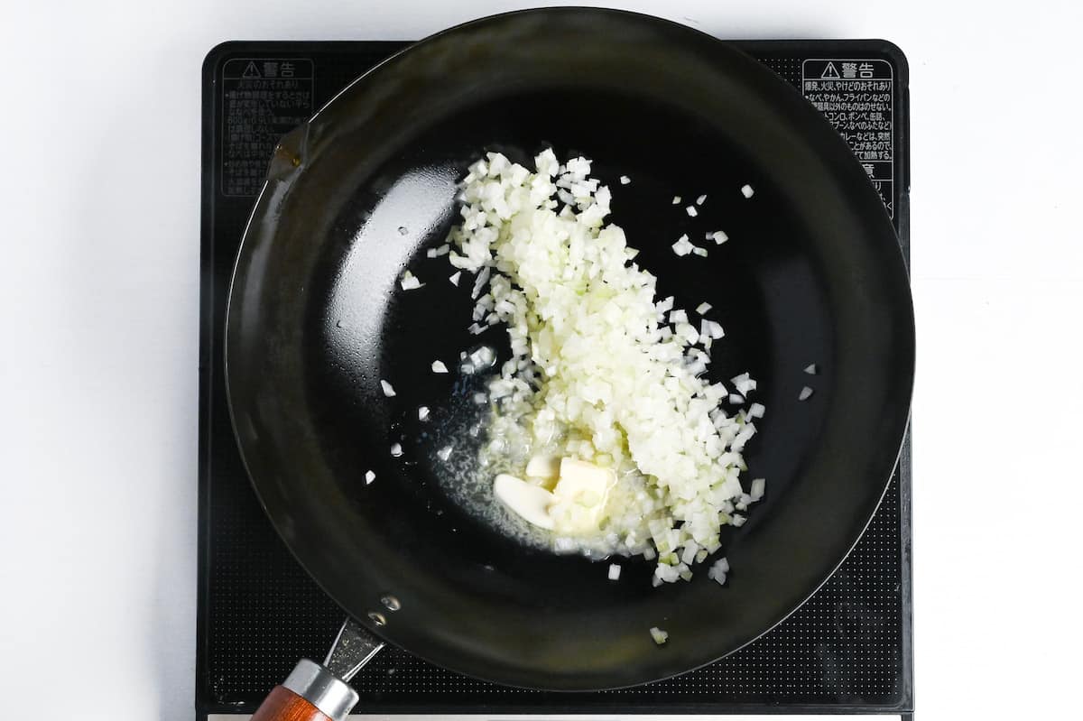 frying onions in butter in a pan