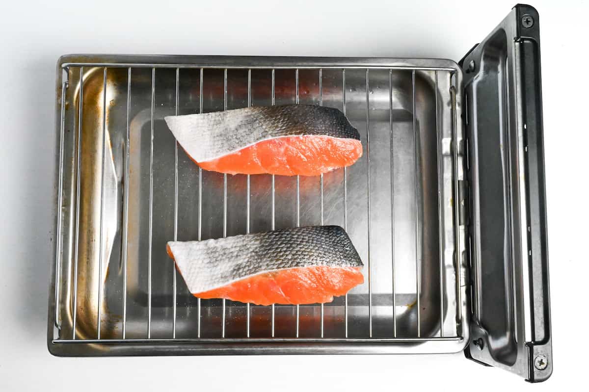 salmon fillets skin-side up on a Japanese fish grill