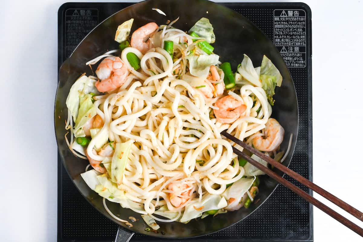 shrimp yaki udon mixed with homemade sauce in wok
