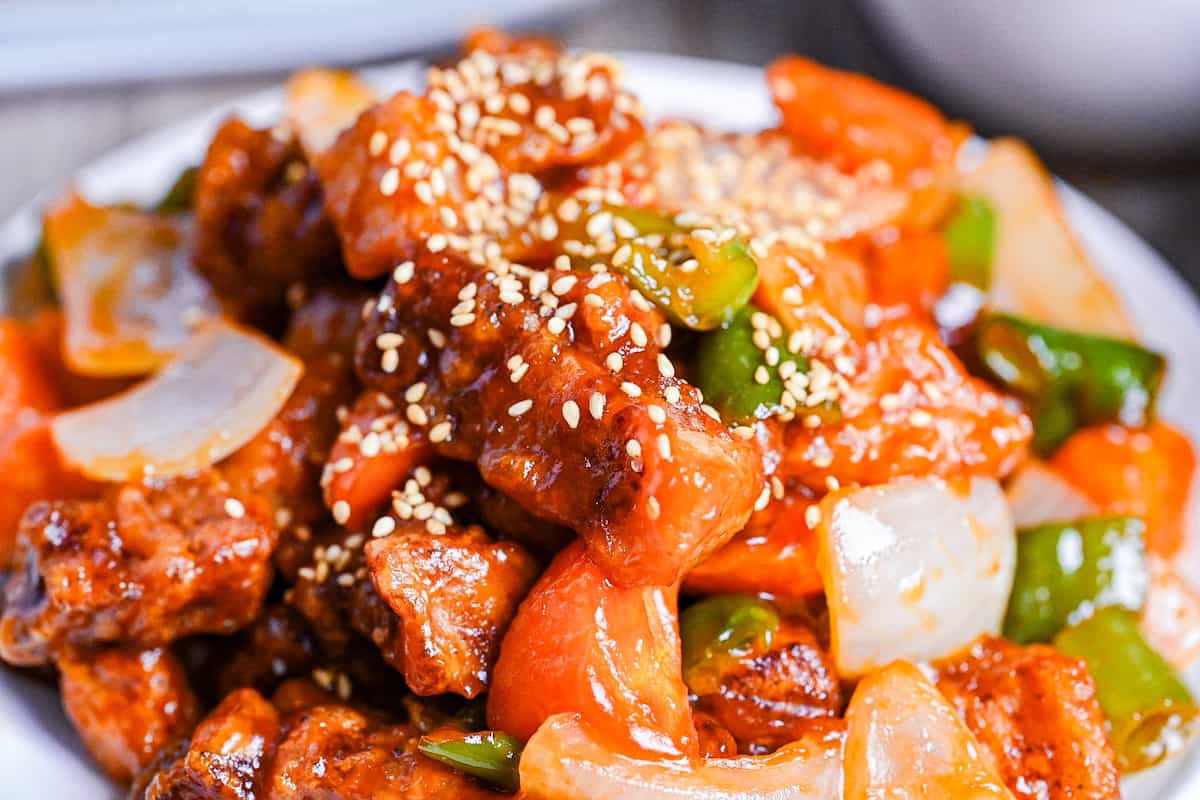 close up of subuta (Japanese sweet and sour pork) sprinkled with sesame seeds