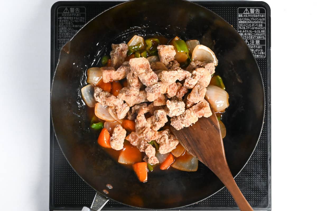 crispy deep fried pork added to subuta sauce and vegetables in a wok