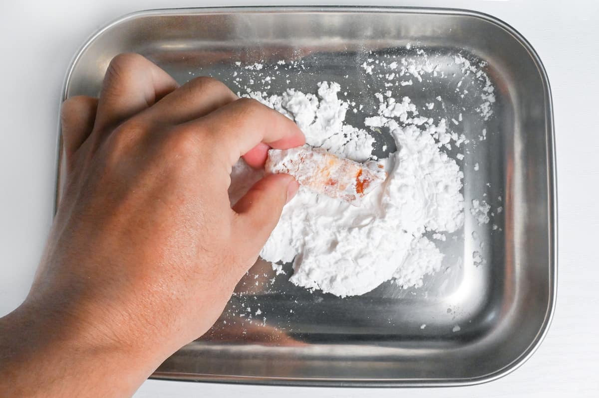 coating a piece of pork belly with cornstarch