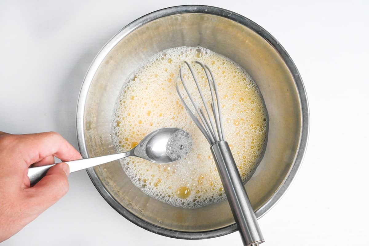 scooping foam out of eggs to make tempura batter