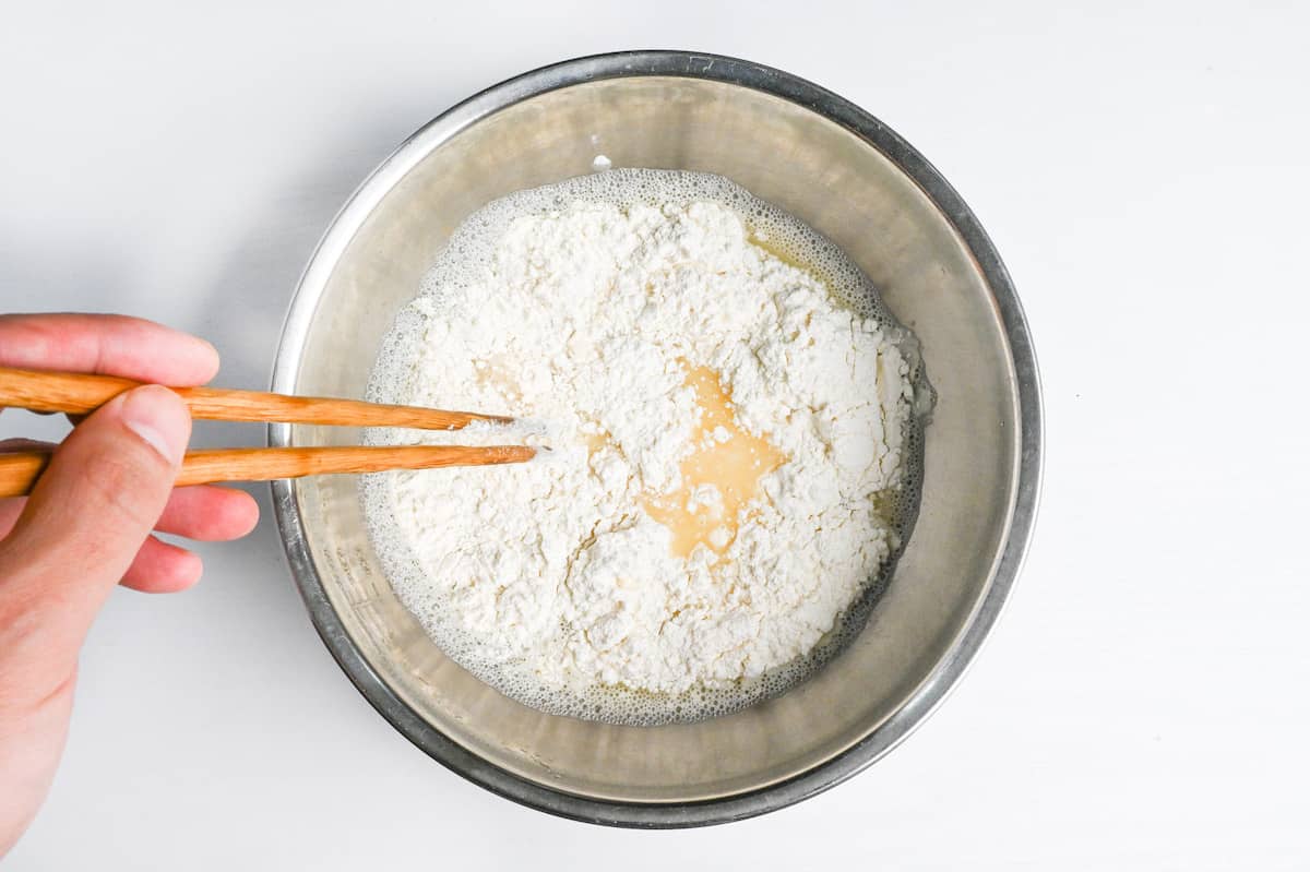 whisking dry ingredients into egg mixture with chopsticks to make tempura batter