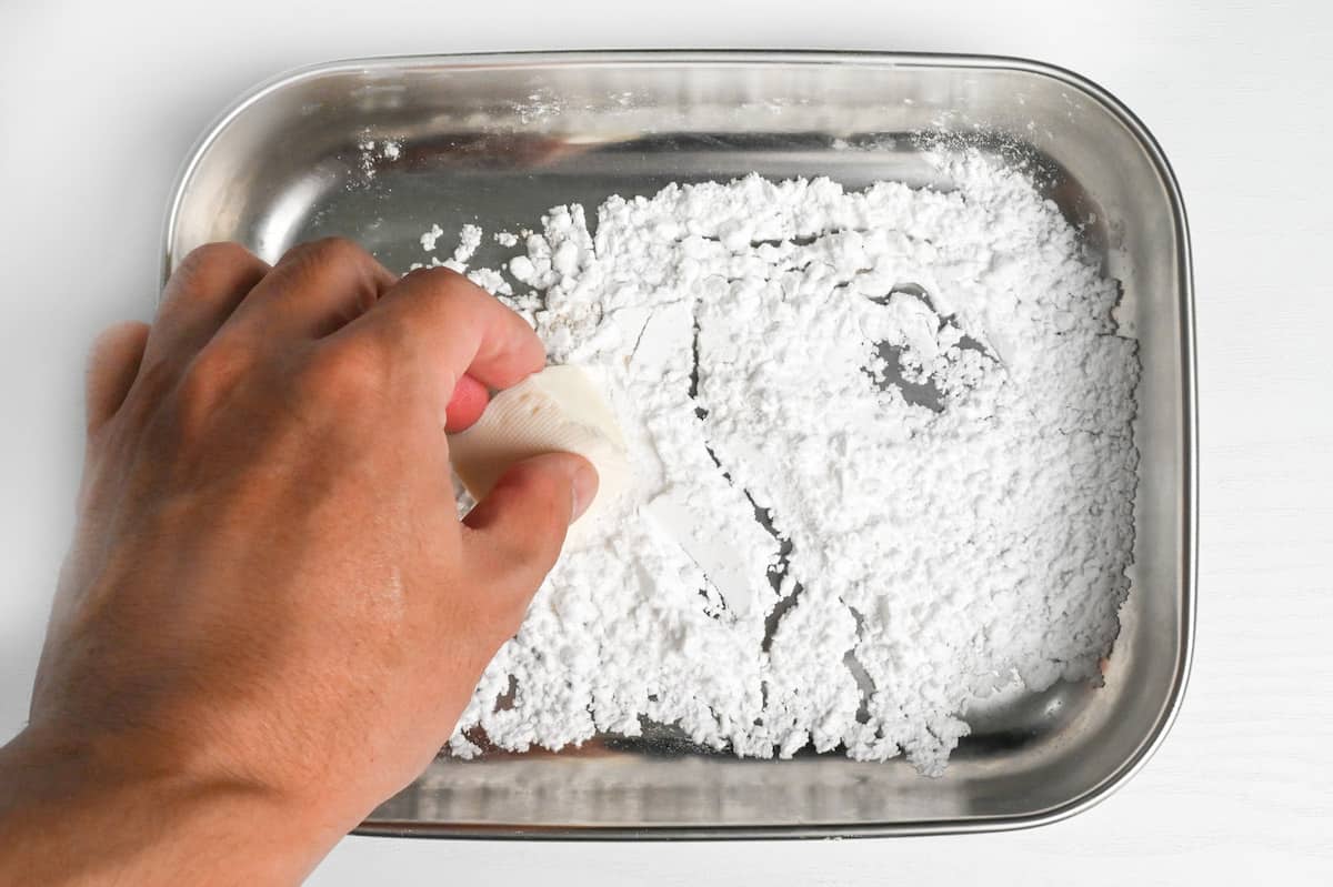 rolling tofu in starch mixture