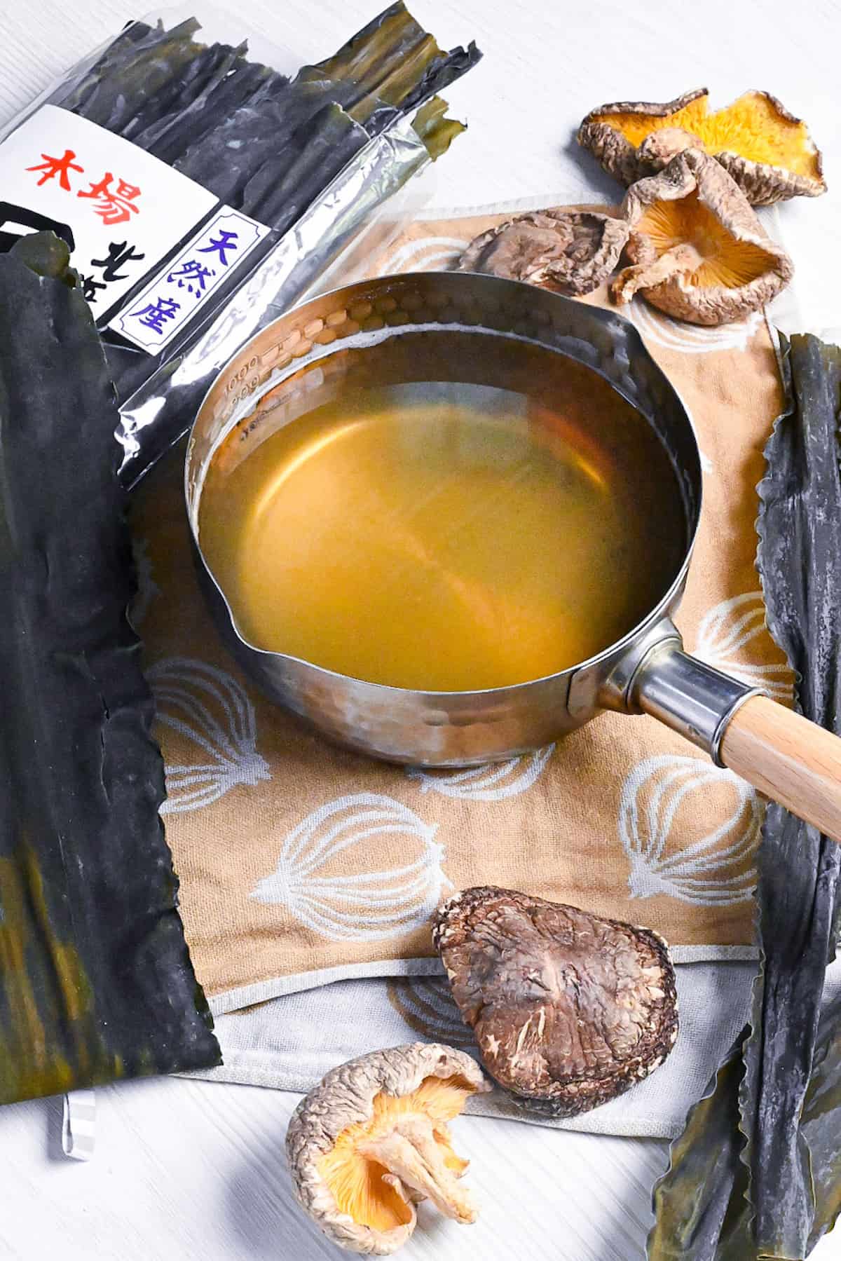 Vegan awase dashi made with kombu dried kelp and shiitake mushrooms in a steel pot