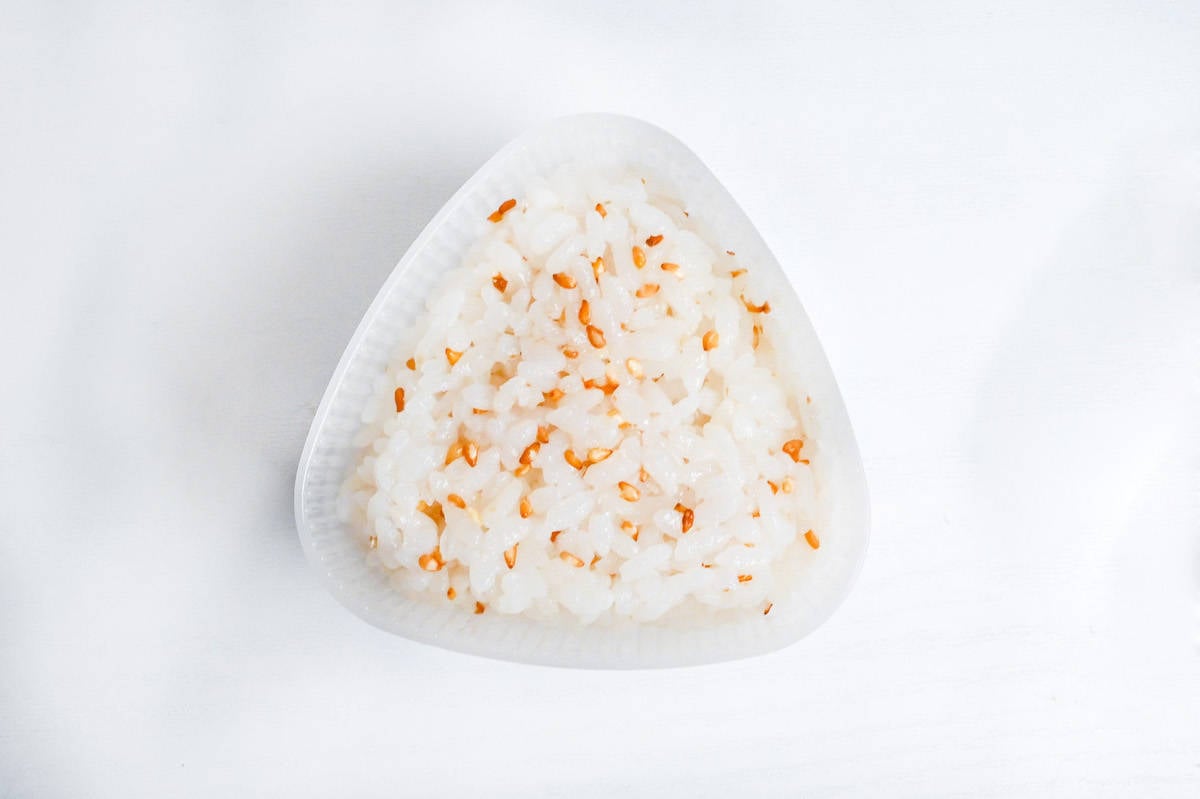 rice mixed with sesame seeds in a plastic rice ball mold
