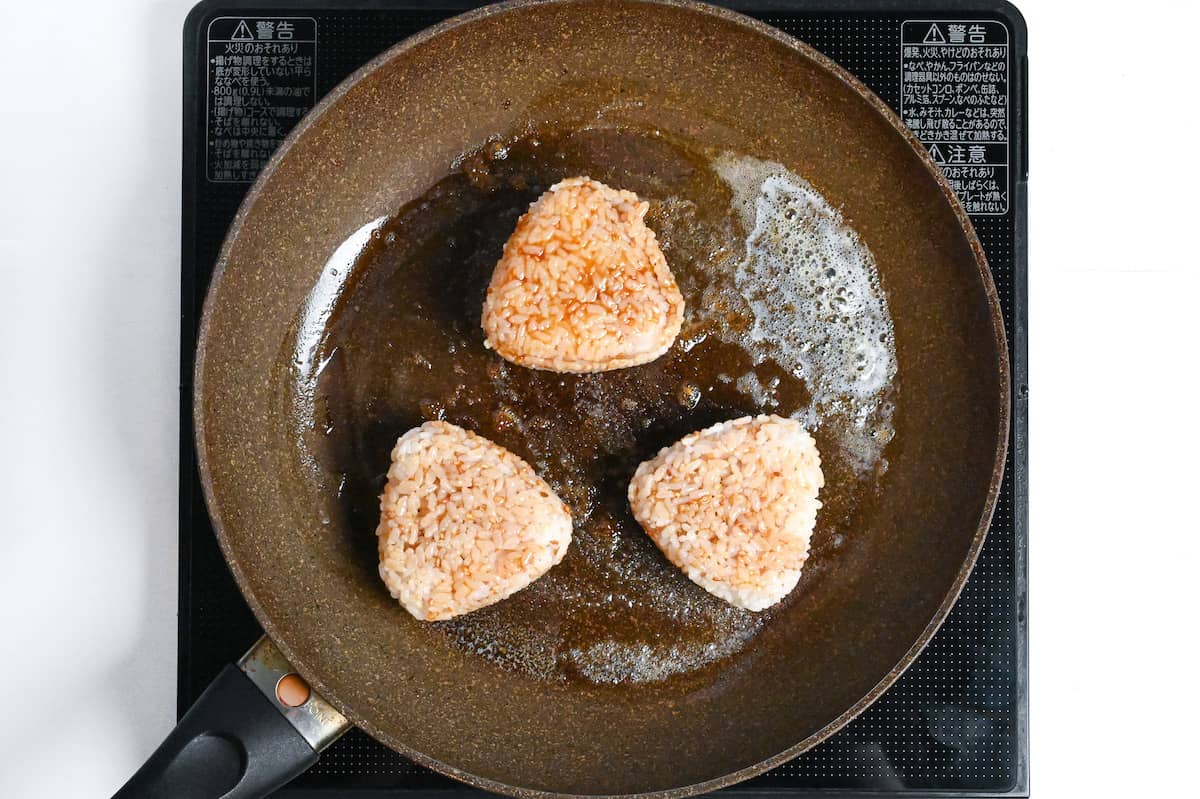 yaki onigiri fying in butter in a pan