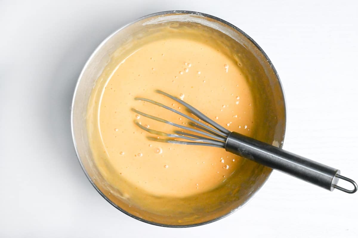 dorayaki batter in a steel mixing bowl with whisk