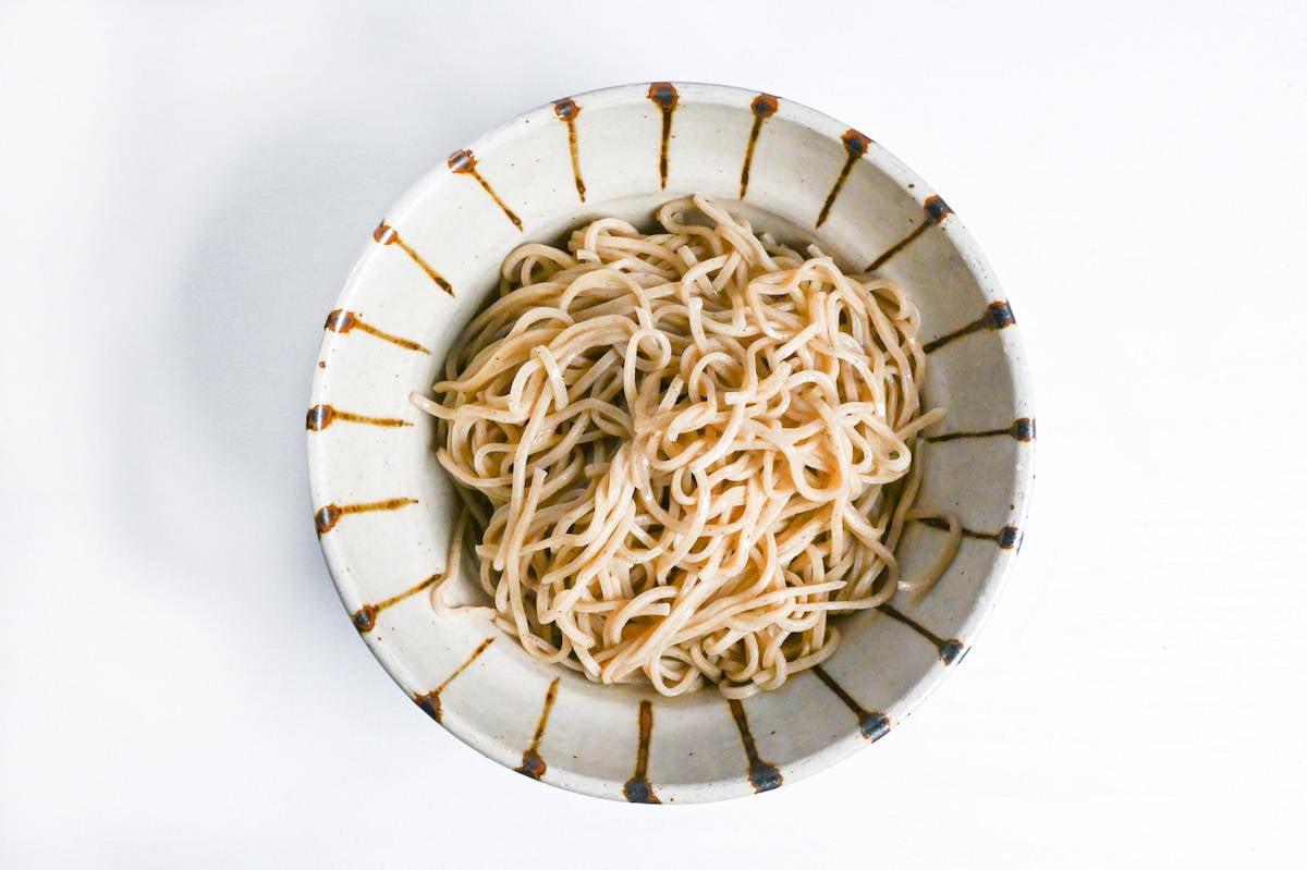 soba noodles in a cream and brown striped bowl