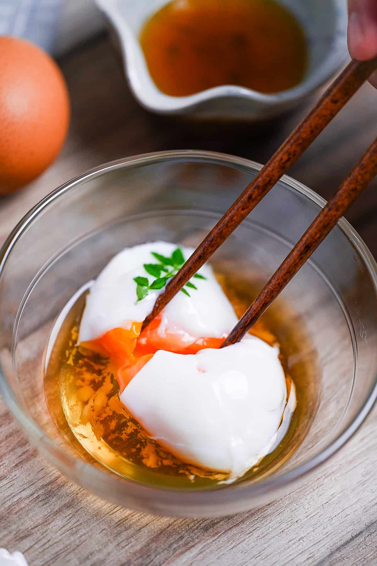 breaking apart onsen tamago (Japanese hot spring egg) with chopsticks to reveal silky yolk