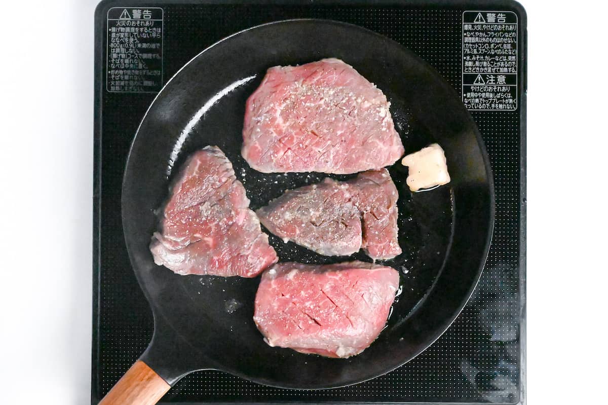 tenderized beef steaks frying in a pan