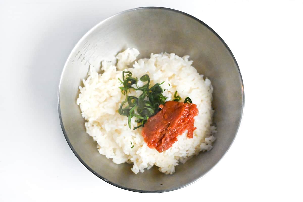 freshly cooked rice in a steel mixing bowl with shredded shiso leaves (Perilla) and umeboshi (pickled plum) paste