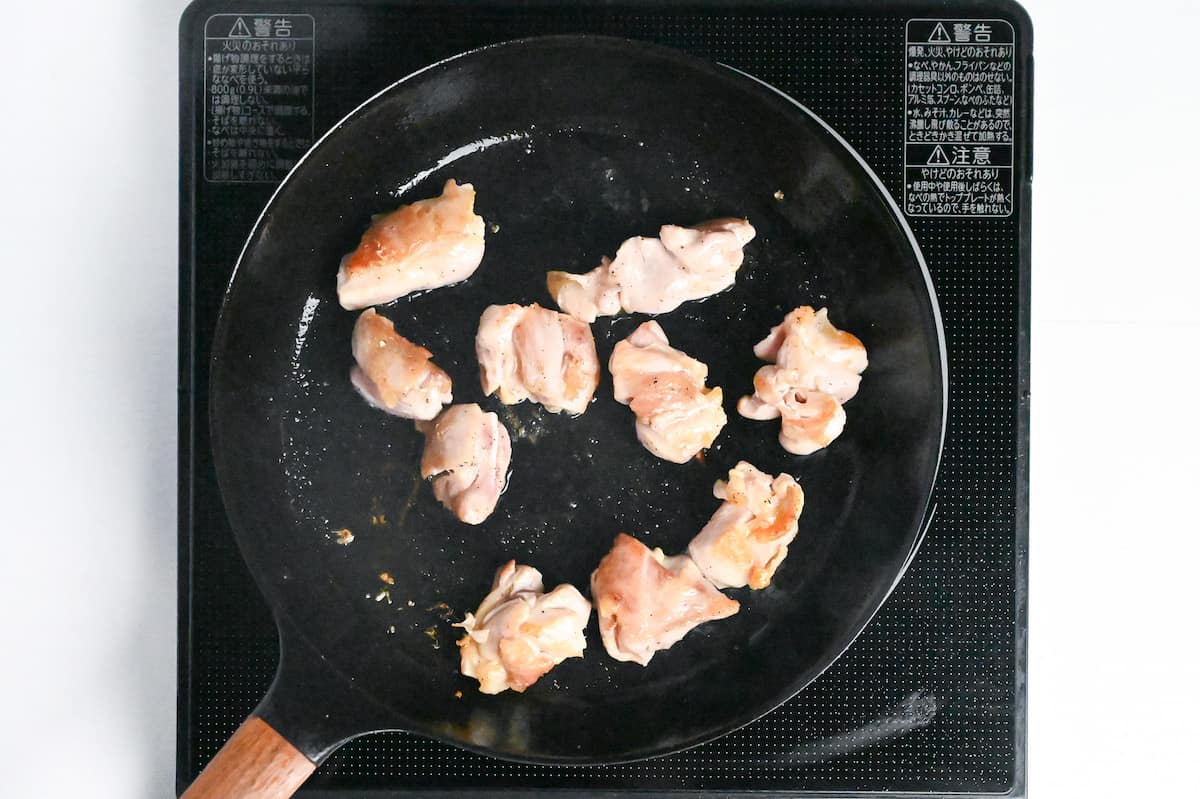 bitesize pieces of chicken thigh frying in a pan
