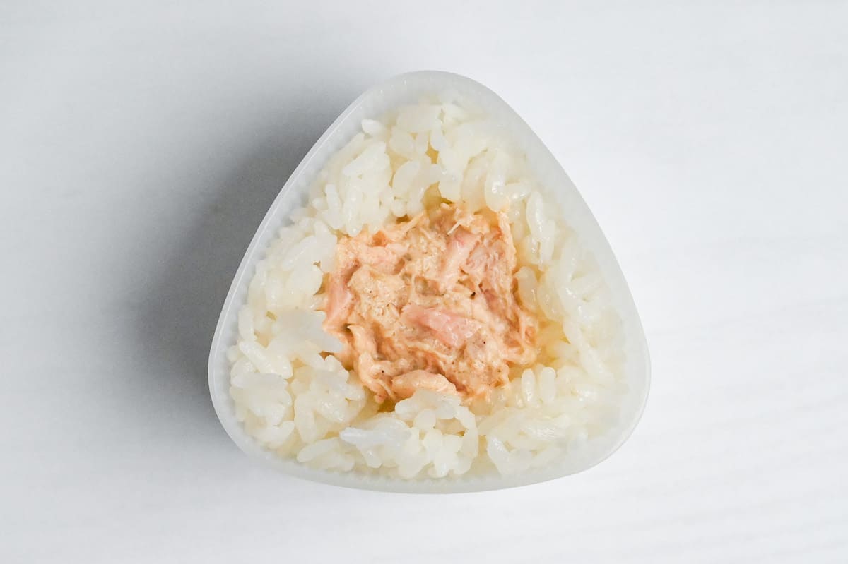 Japanese white rice in an onigiri (rice ball) mold with tuna mayo filling in the center