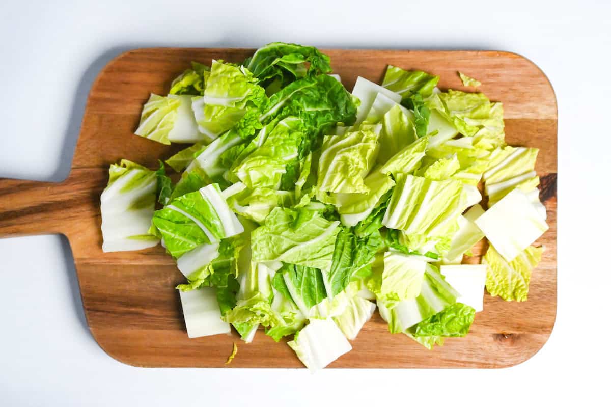napa cabbage cut into squares on a wooden chopping board