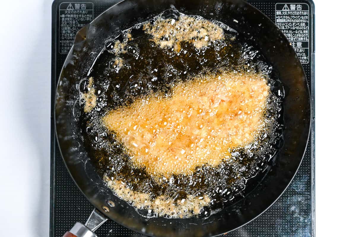 chicken katsu frying in a pot of oil