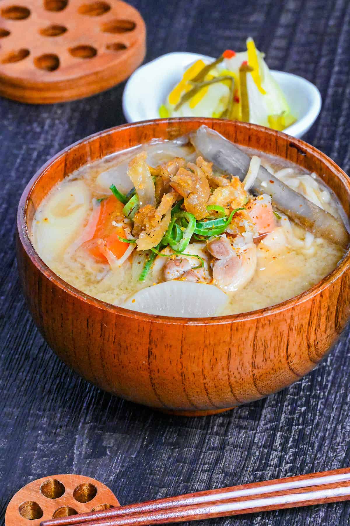 Japanese Chicken Miso Soup (Torijiru) in a wooden bowl topped with green onion and strips of crispy chicken skin